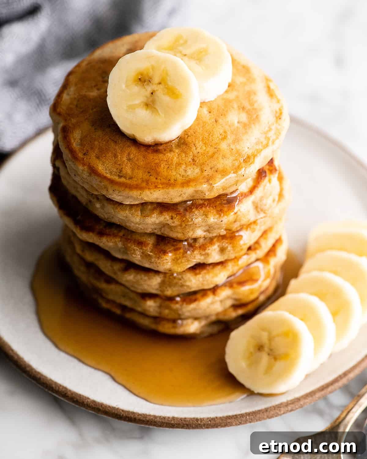 Banana pancakes overhead view overhead view of a stack of 6 banana pancakes with syrup and bananas
