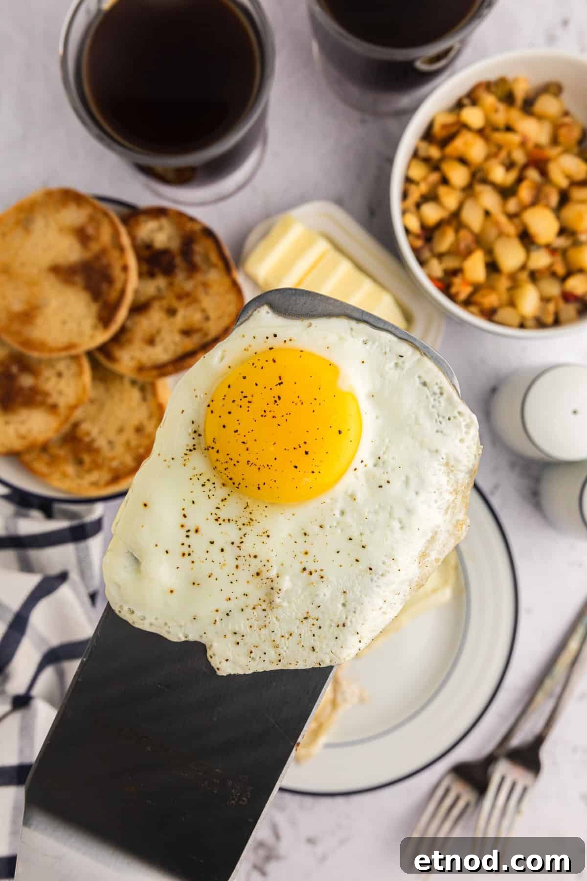 Perfect Blackstone Fried Eggs Recipe for Crispy Edges and Runny Yolks 2 Using metal spatula for place Blackstone Fried Egg on plate