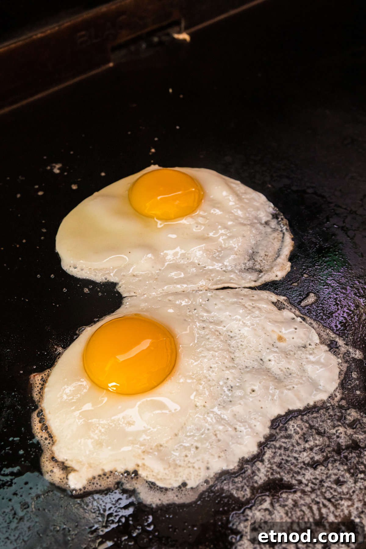 Perfect Blackstone Fried Eggs Recipe for Crispy Edges and Runny Yolks 4 Fried Egg on buttered Blackstone griddle