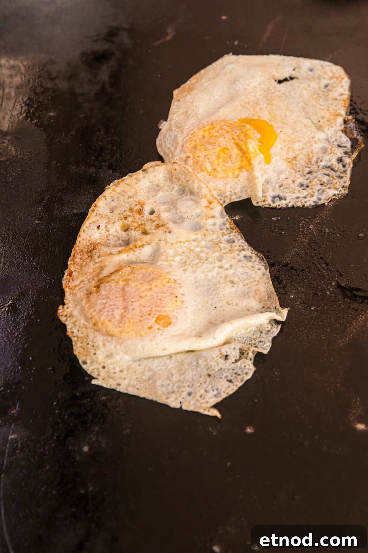 Perfect Blackstone Fried Eggs Recipe for Crispy Edges and Runny Yolks 5 Blackstone Fried Egg flipped to other side for cooking on griddle