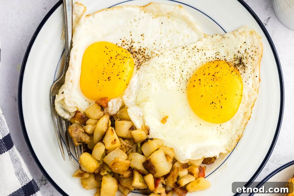 Perfect Blackstone Fried Eggs Recipe for Crispy Edges and Runny Yolks 6 Blackstone Fried Eggs on plate with breakfast potatoes