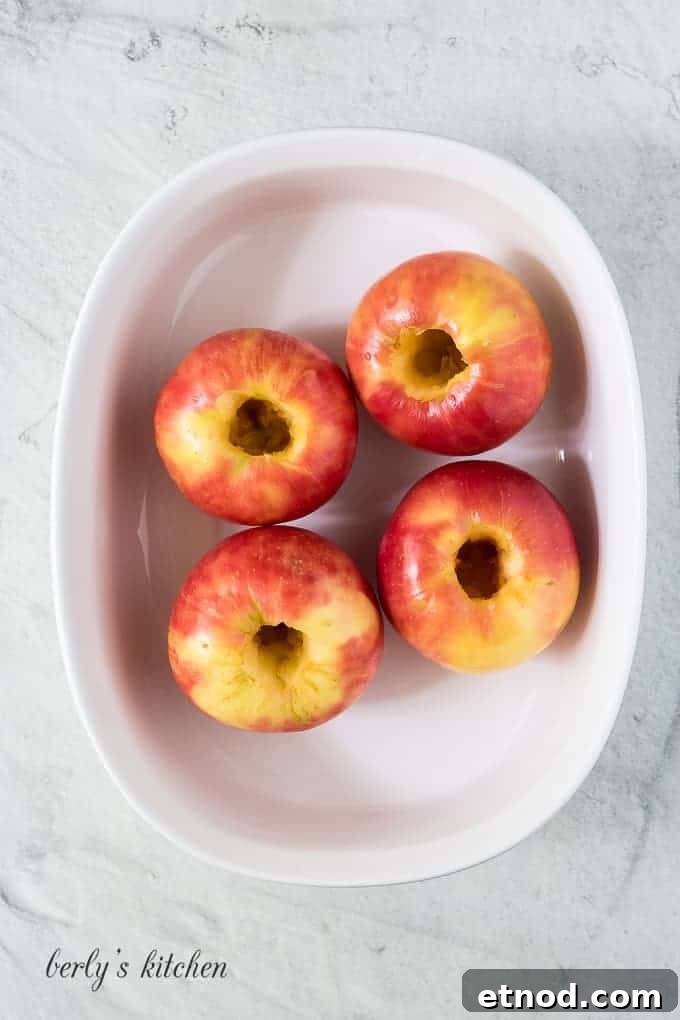 Warm Cinnamon Baked Apples with Caramel Drizzle 4 Four washed and cored apples in a large baking dish.