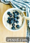an overhead shot of a bowl of overnight oats topped with blueberries