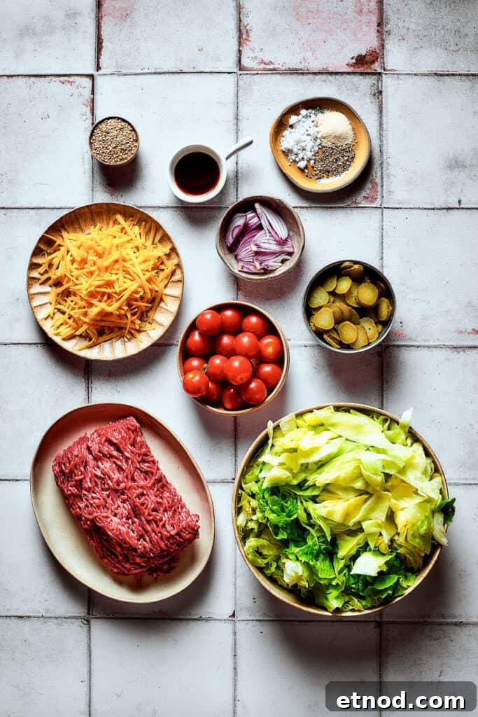 This Big Mac Salad brings all the classic flavors you love but with a healthier twist. It's a guilt-free way to satisfy your burger cravings. The ingredients for Big Mac salad, arranged on a work surface.