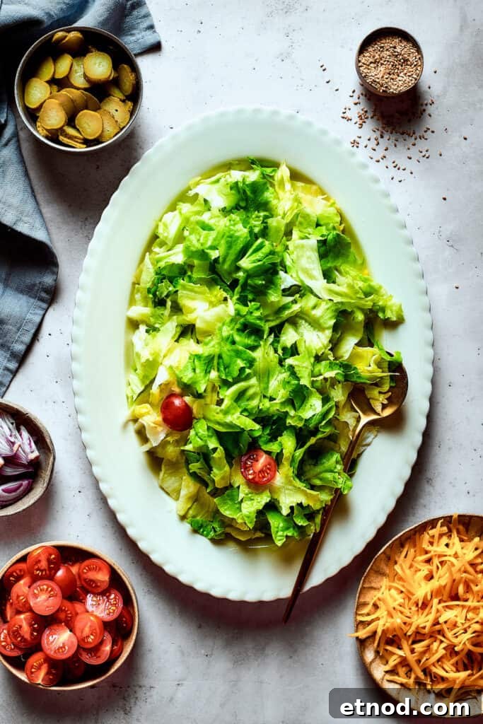 This Big Mac Salad brings all the classic flavors you love but with a healthier twist. It's a guilt-free way to satisfy your burger cravings. A leafy salad on an oval platter.