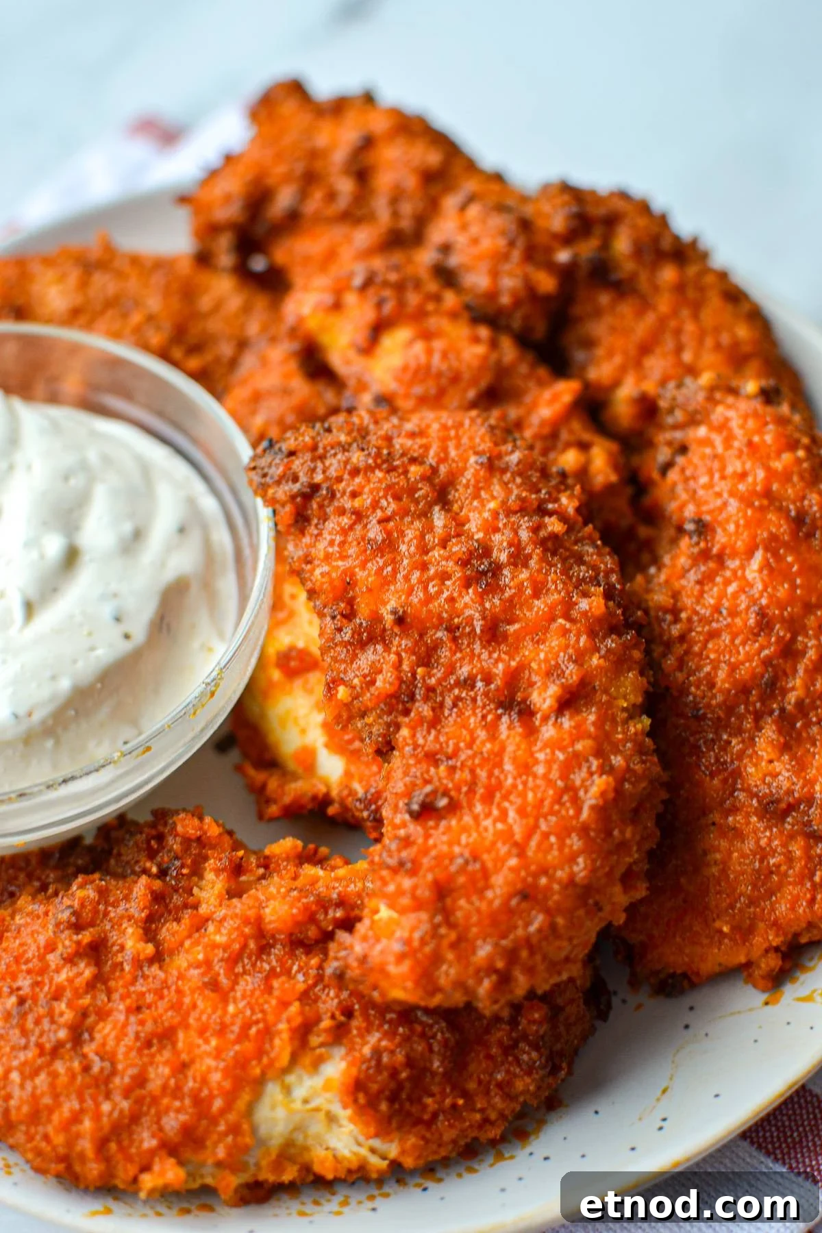 Crispy Buffalo Chicken Tenders in the Air Fryer 2 A plate of buffalo chicken tenders with a ranch dipping sauce on the side.