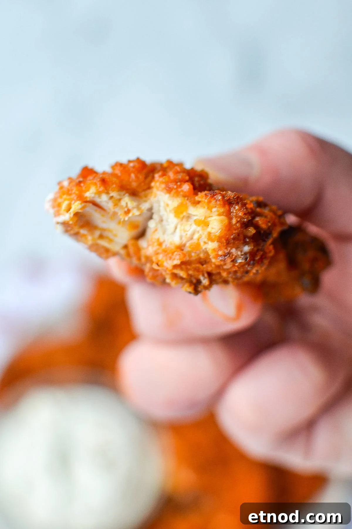 Crispy Buffalo Chicken Tenders in the Air Fryer 11 A piece of buffalo chicken tenders with a bite taken out of it.