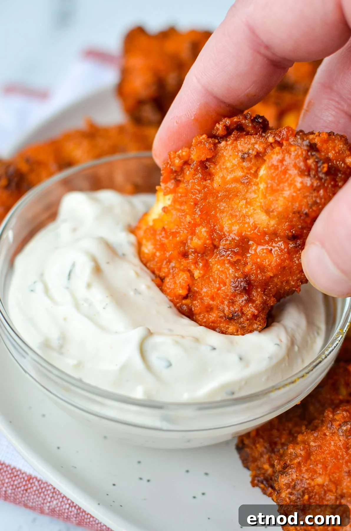 Crispy Buffalo Chicken Tenders in the Air Fryer 8 Dipping buffalo chicken tenders into a ranch dip.