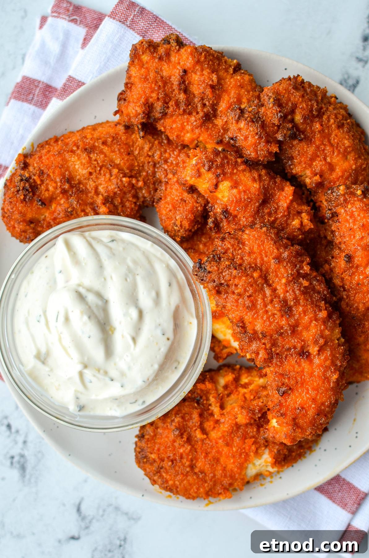Crispy Buffalo Chicken Tenders in the Air Fryer 10 A plate of buffalo chicken tenders with a small bowl of ranch dip.