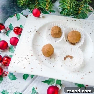 Biscoff Truffles Made Without Cream Cheese — Simple No-Bake Recipe 5 Scrumptious Biscoff truffles on white plate. Decorated with red Christmas baubles on the side.