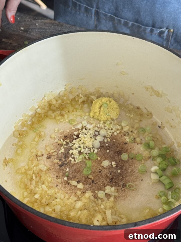 Healing Ginger Chicken Soup Recipe for Cold Relief 5 aromatics sauteing in a dutch oven with olive oil