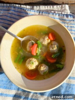 Healing Ginger Chicken Soup Recipe for Cold Relief 10 chicken soup with ginger in a white bowl with a spoon in it