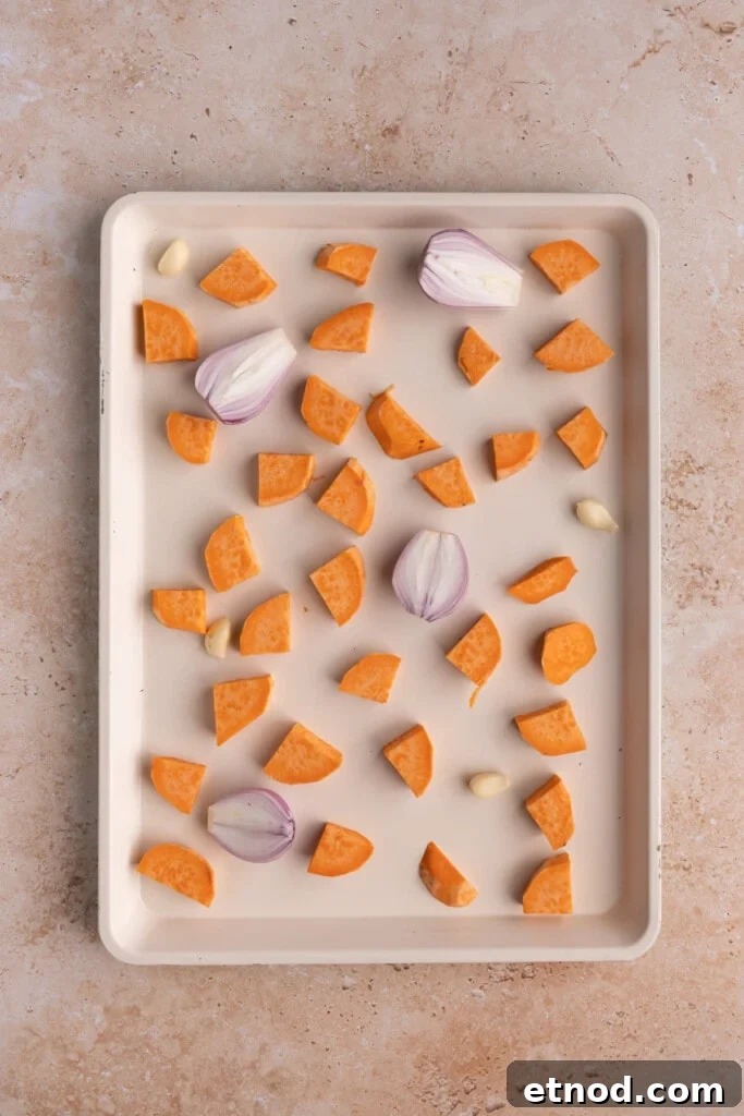30-Minute Creamy Sweet Potato Pasta Sauce Recipe 5 Baking sheet with sweet potato, shallot, and garlic.