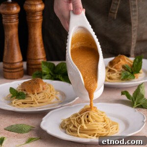 30-Minute Creamy Sweet Potato Pasta Sauce Recipe 9 Pouring Sweet Potato Pasta Sauce onto spaghetti
