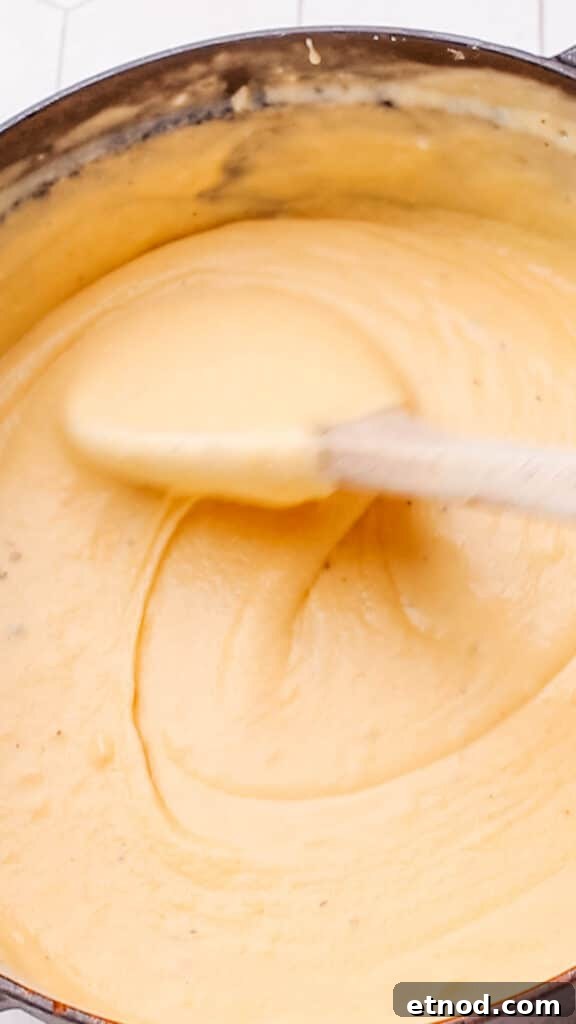 Stirring cheddar cheese sauce for maroni and cheese.