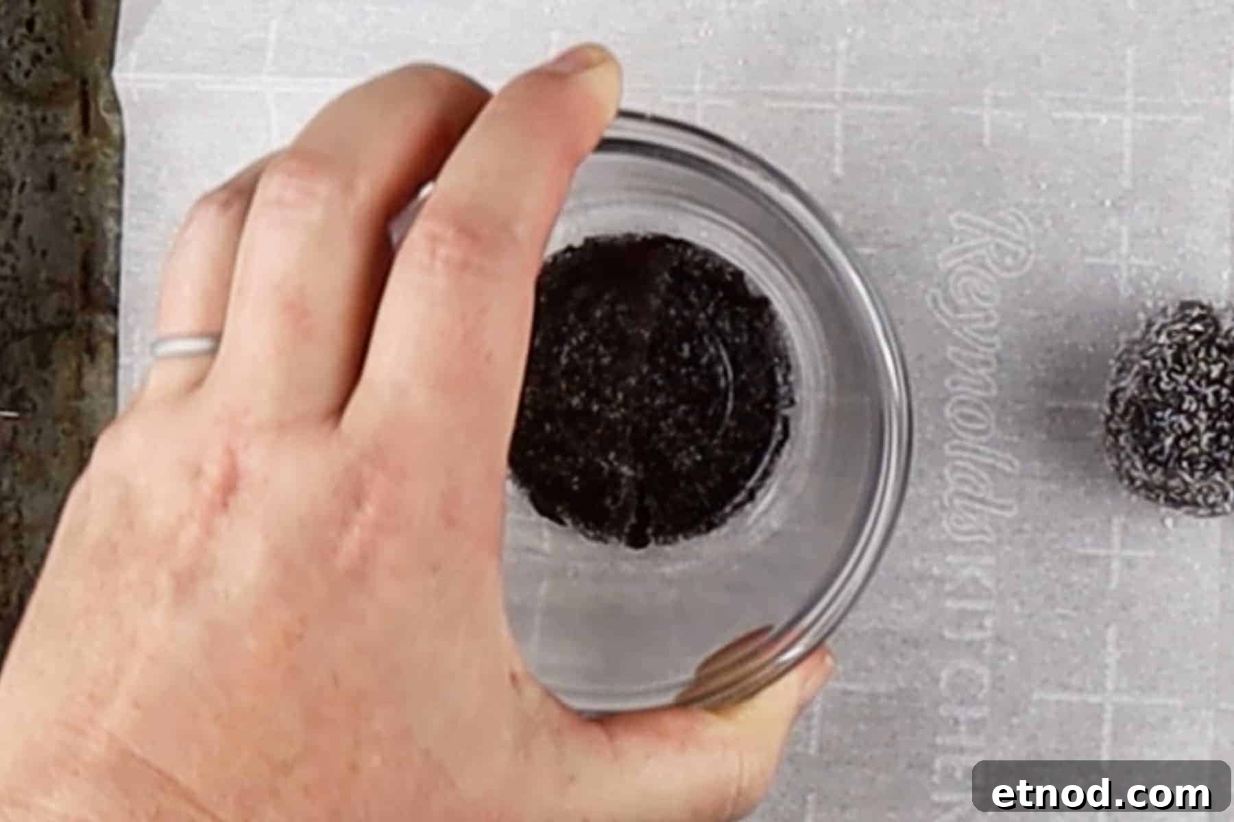 Use a small glass bowl to flatten cookie dough rounds on a parchment-lined baking sheet.