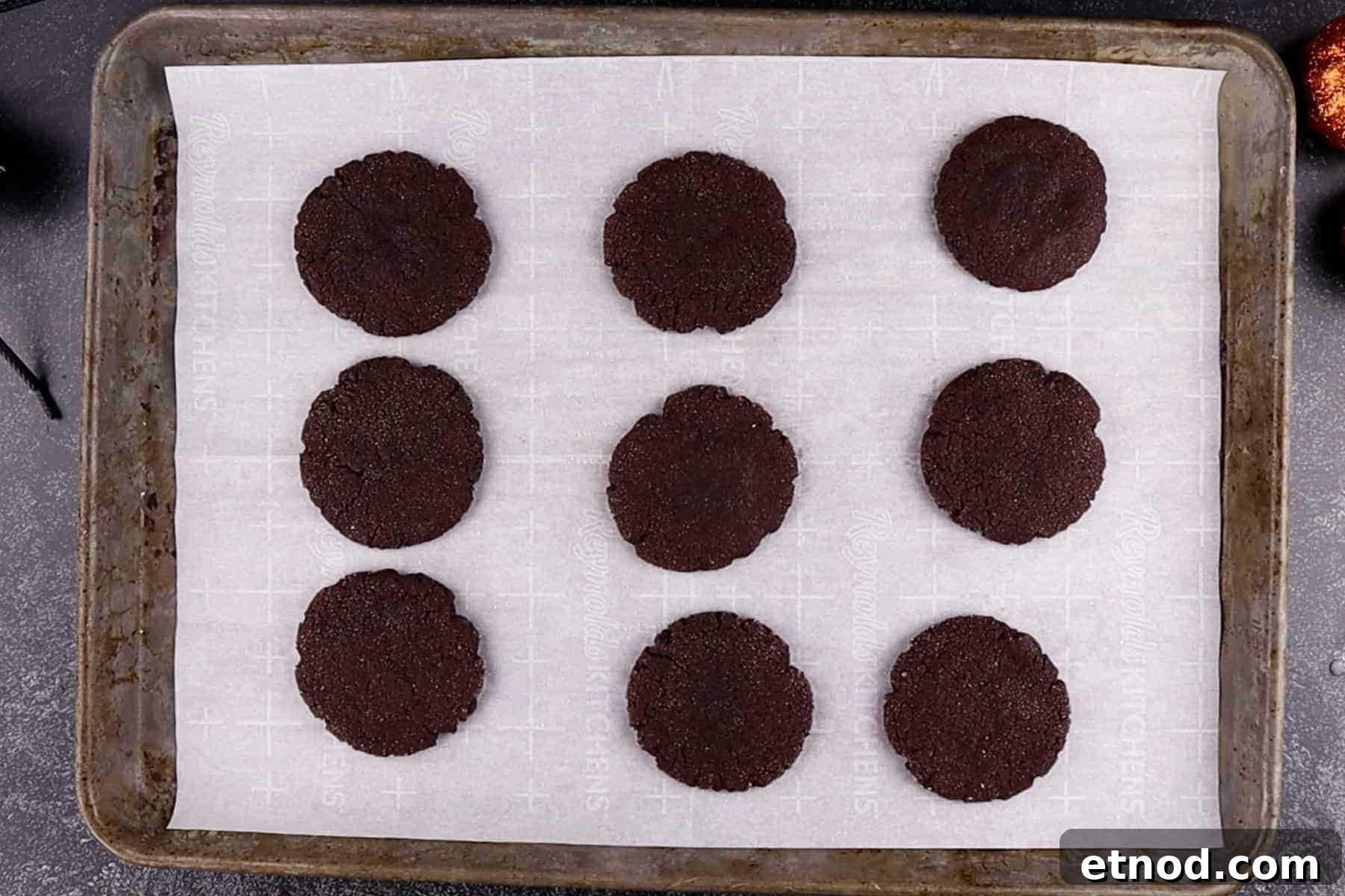 Chocolate Sugar Cookies baked and on a parchment-lined baking sheet.