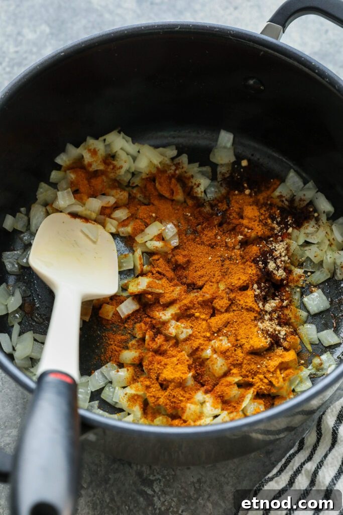 Creamy Vegan Vegetable Korma Recipe — Flavorful Indian Curry 5 Onions and korma spices cooked in pot by Flora & Vino