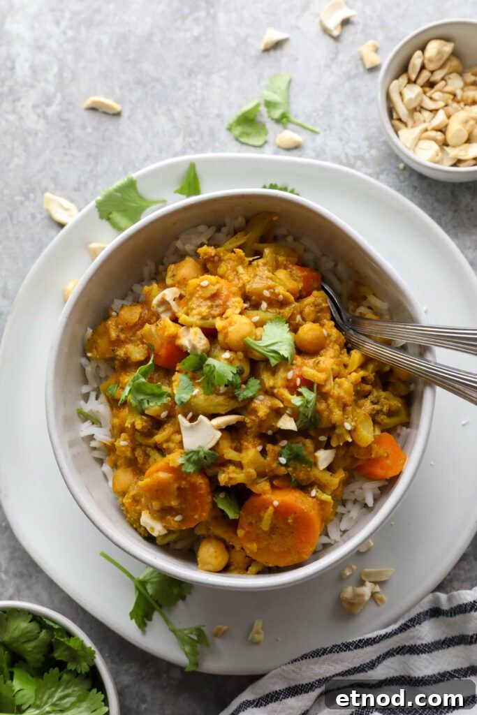 Creamy Vegan Vegetable Korma Recipe — Flavorful Indian Curry 9 Vegan Vegetable Korma served with spoons, cilnatro, and cashews by Flora & Vino