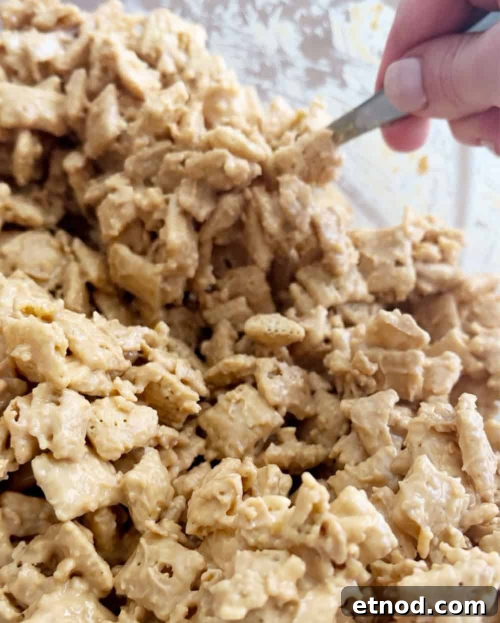 Valentine’s Day Puppy Chow Recipe (Muddy Buddies Treats) 6 mix chex with spoon.