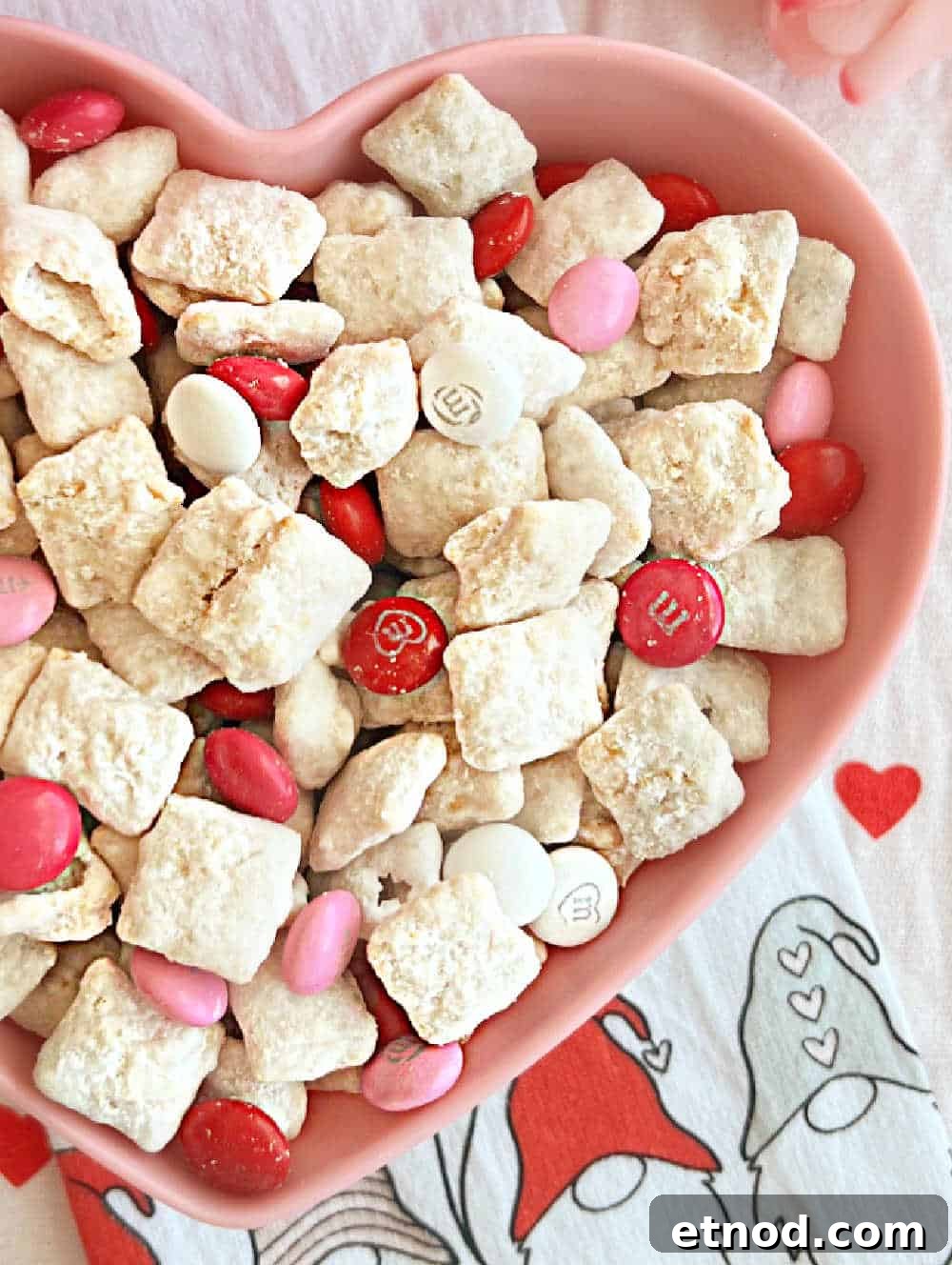 Valentine’s Day Puppy Chow Recipe (Muddy Buddies Treats) 8 valentine muddy buddies in heart bowl.