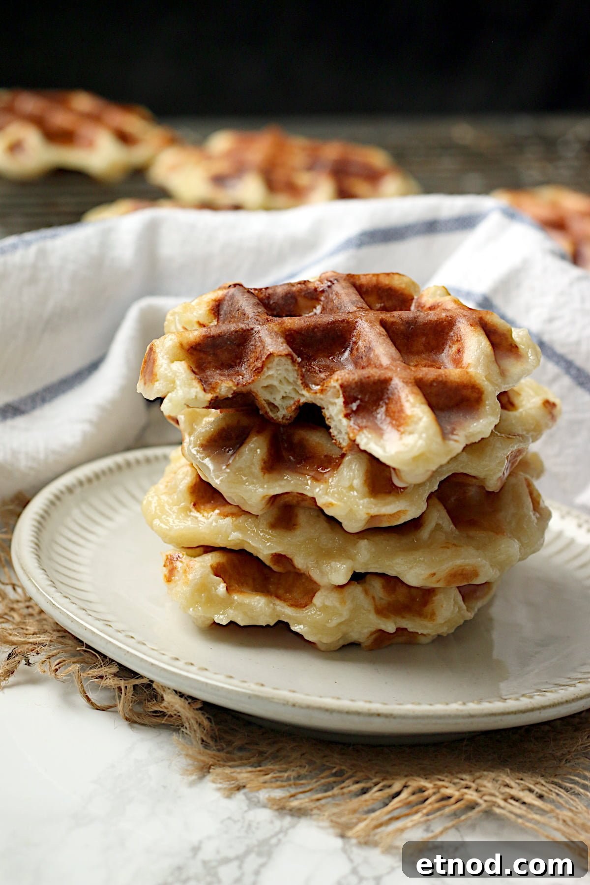 A stack of honey cruller waffles on a white plate.