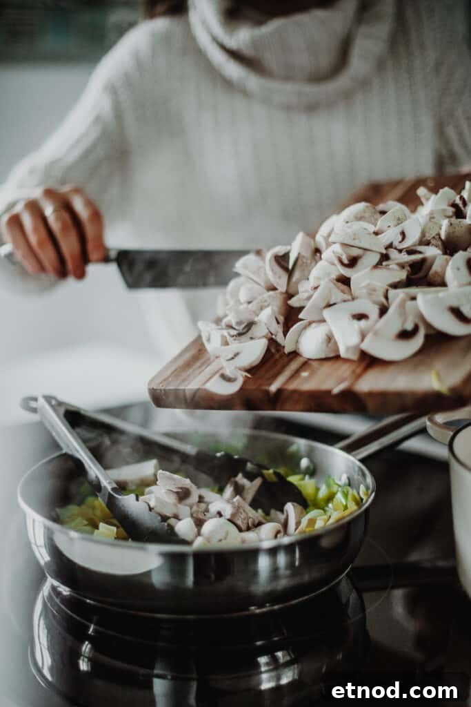 Creamy Leek and Mushroom Pie Recipe for Cozy Dinners 5 adding the mushrooms into the saucepan