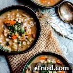 A closer overhead view of three bowls of mushroom barley soup