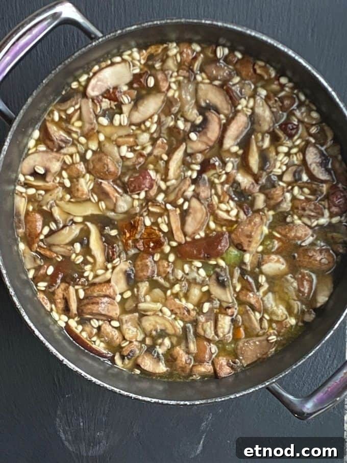 An overhead view of mushroom barley soup in a large pot