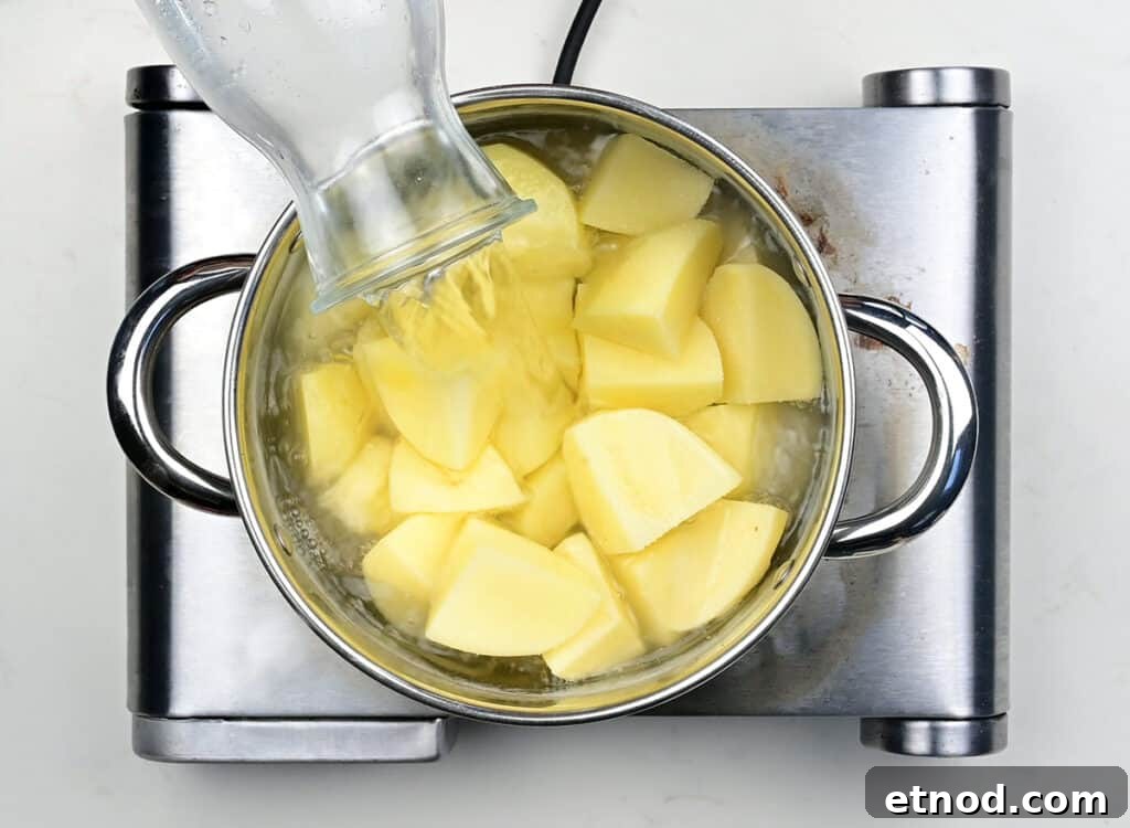 Crispy Roast Potatoes Cooked in Goose Fat 5 Cubed potatoes in a saucepan