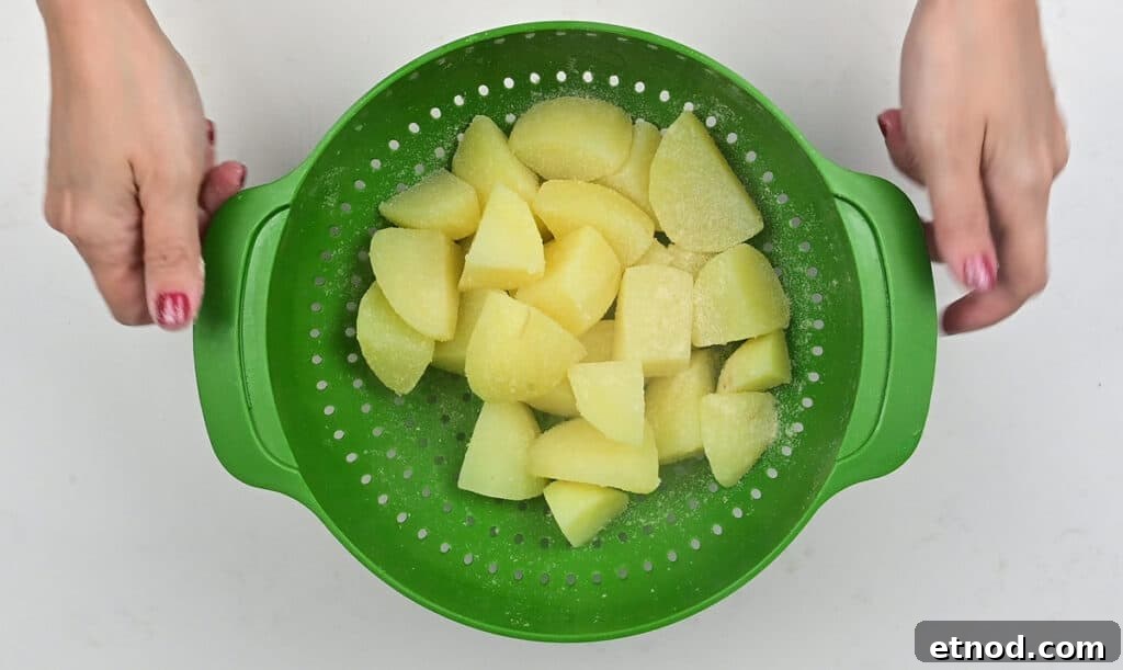 Crispy Roast Potatoes Cooked in Goose Fat 6 shaking parboiled potatoes in a colander to rough up the edges prior to roasting