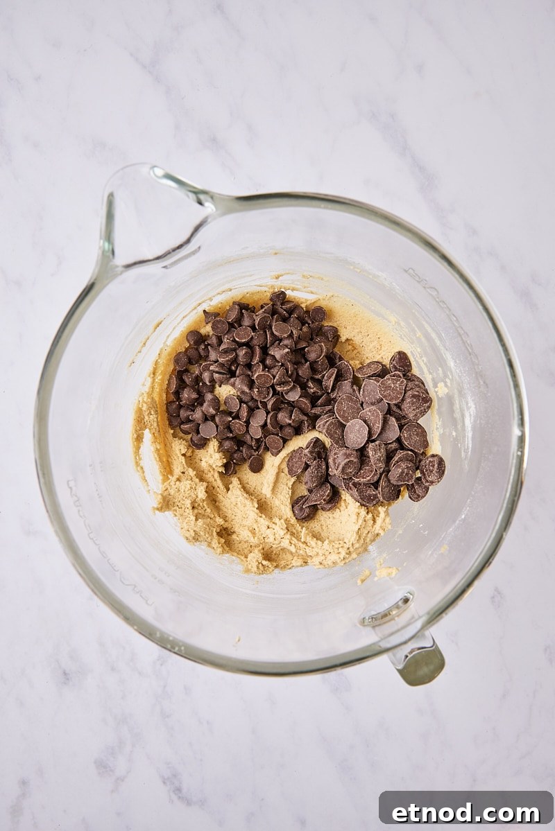 Brown Butter Chocolate Chip Cookies with Extra Chewiness 10 Chocolate chips added to cookie dough in glass mixer bowl