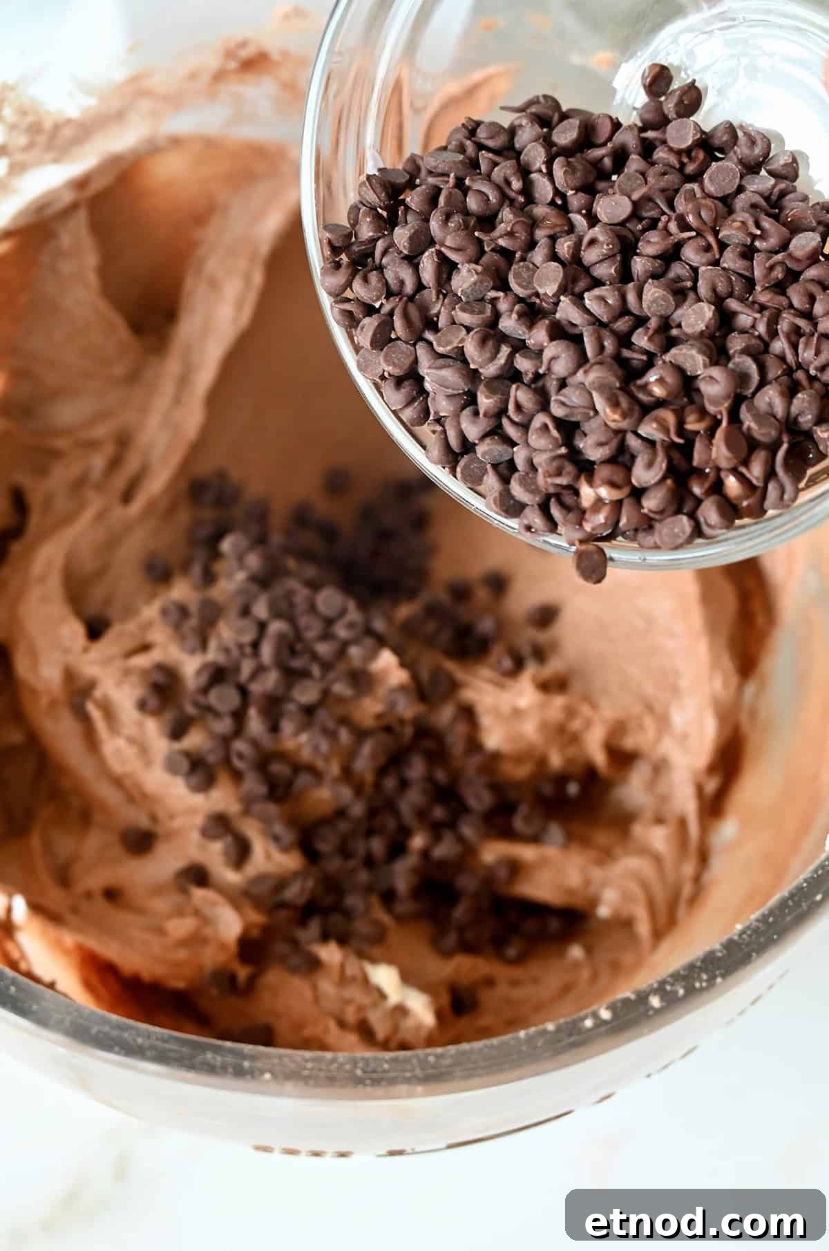Decadent Chocolate Loaf Cake Recipe for Moist, Rich Results 8 Folding mini chocolate chips into chocolate cake batter.
