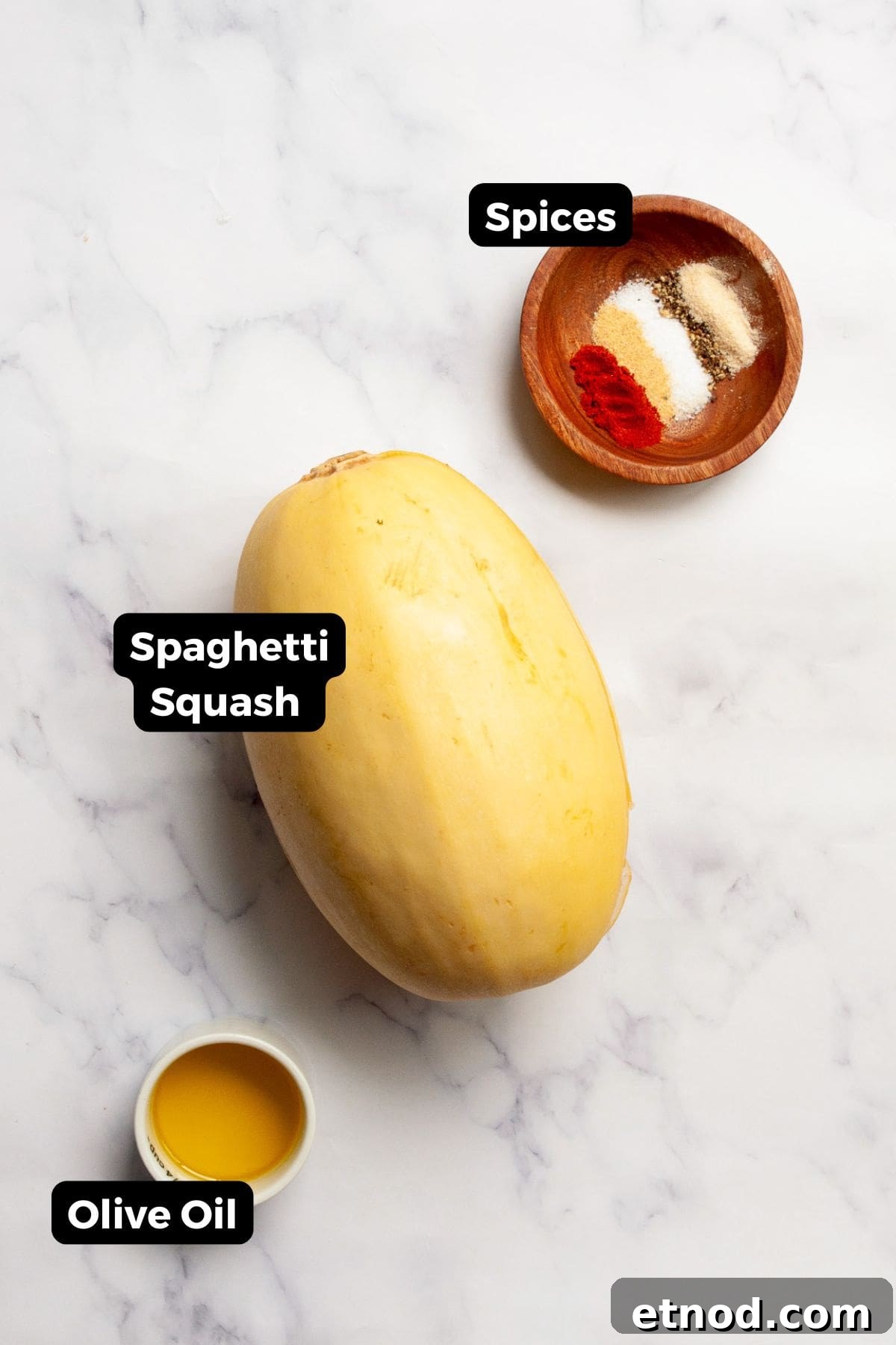 Crispy Air-Fried Spaghetti Squash Recipe 3 All labeled ingredients for air fryer spaghetti squash, including spaghetti squash, olive oil, salt, black pepper, garlic powder, onion powder, and paprika.