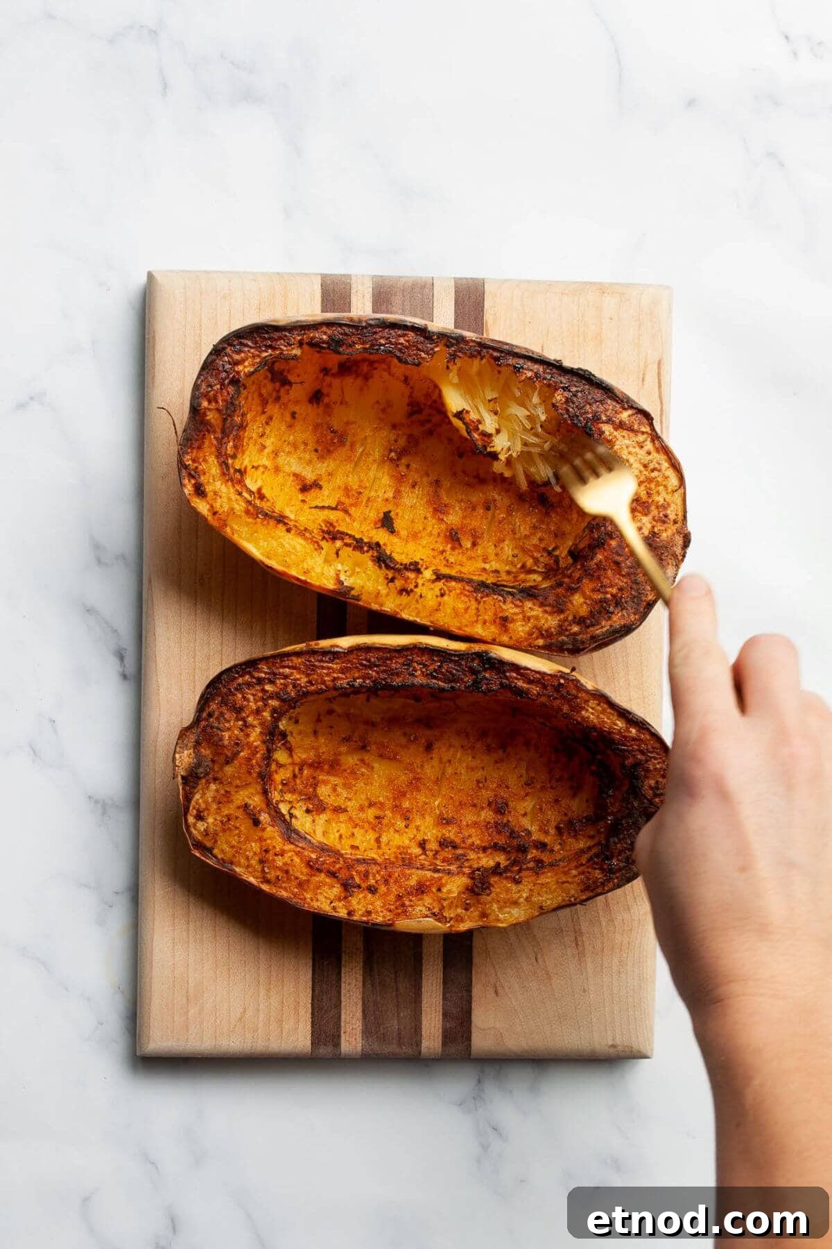 Crispy Air-Fried Spaghetti Squash Recipe 8 Cooked spaghetti squash being fluffed with a fork to create low-carb noodles.