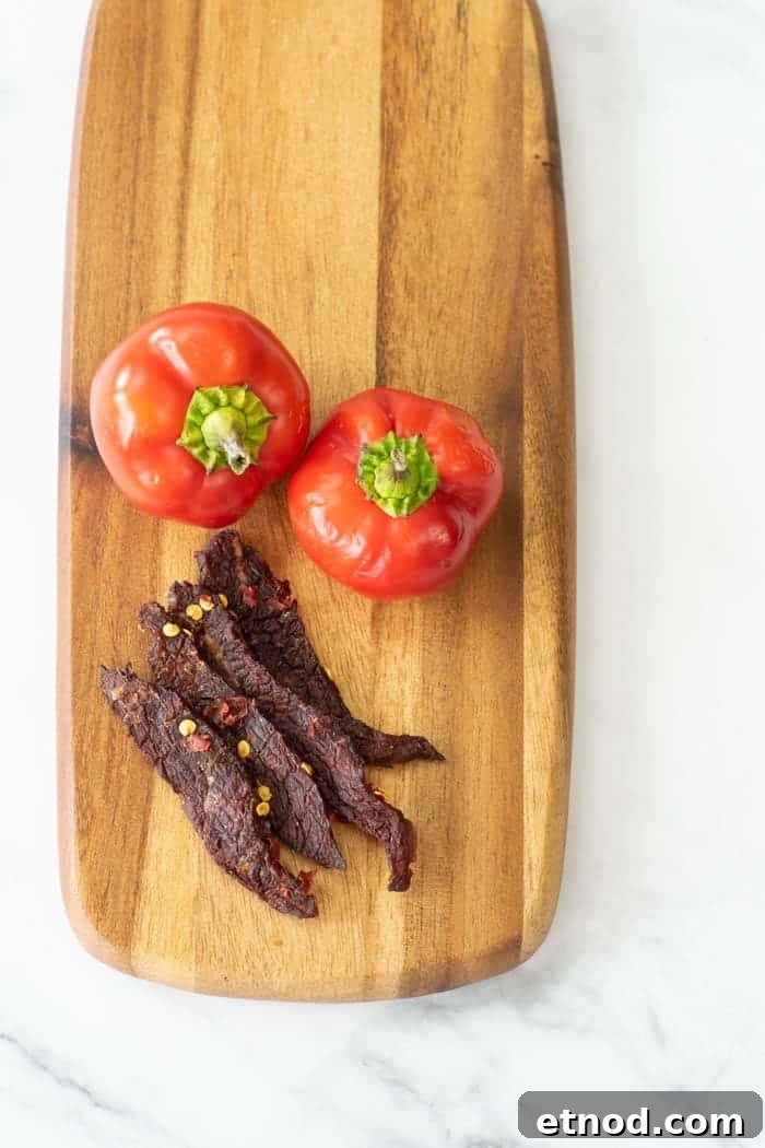 Cherry Bomb Beef Jerky: Spicy-Sweet Gourmet Snack 16 Cherry bomb beef jerky on cutting board with peppers