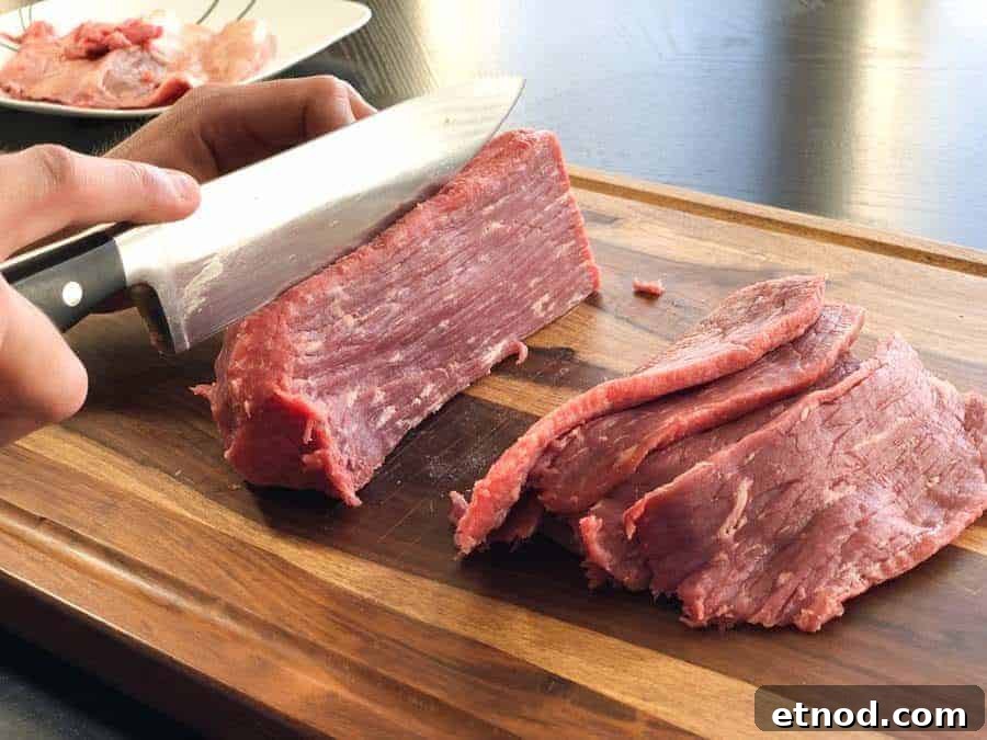 Cherry Bomb Beef Jerky: Spicy-Sweet Gourmet Snack 4 Eye of round beef roast being sliced in cutting board