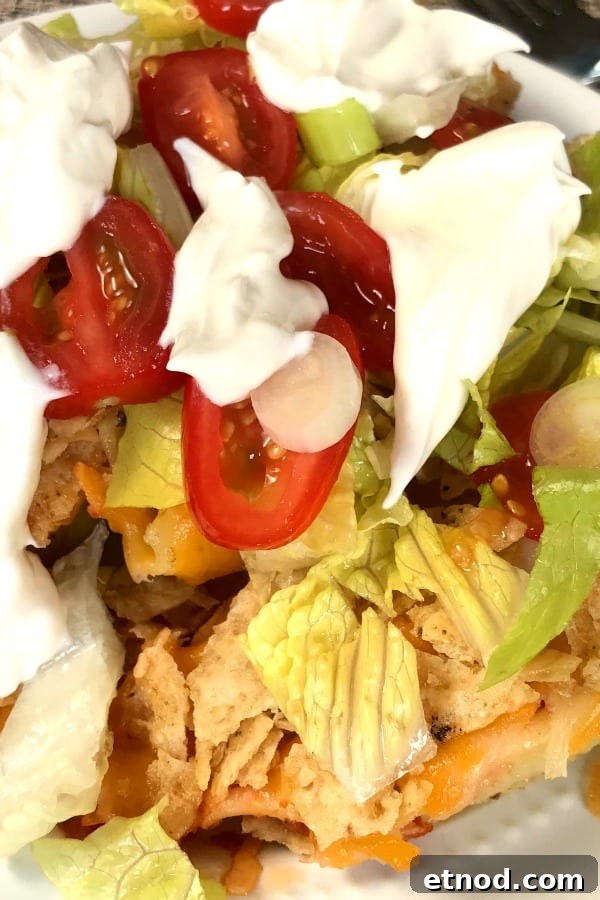 Pasta Shell Tacos Recipe: Crispy Taco Filling in Pasta Shells 3 Close up of tacos stuffed shells with cherry tomatoes, lettuce and sour cream.