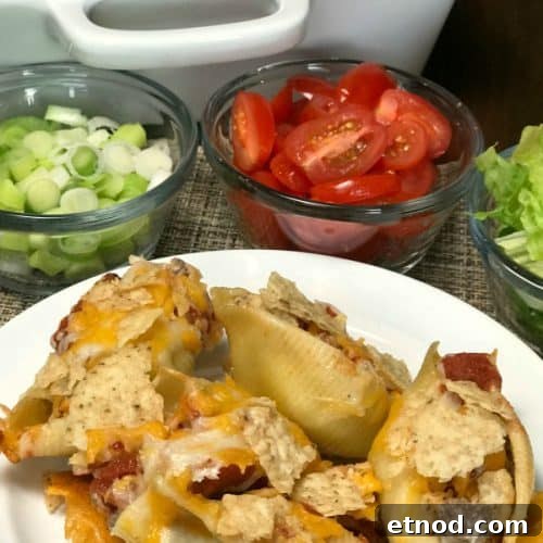 Pasta shell tacos covered with tortilla chips on a white plate