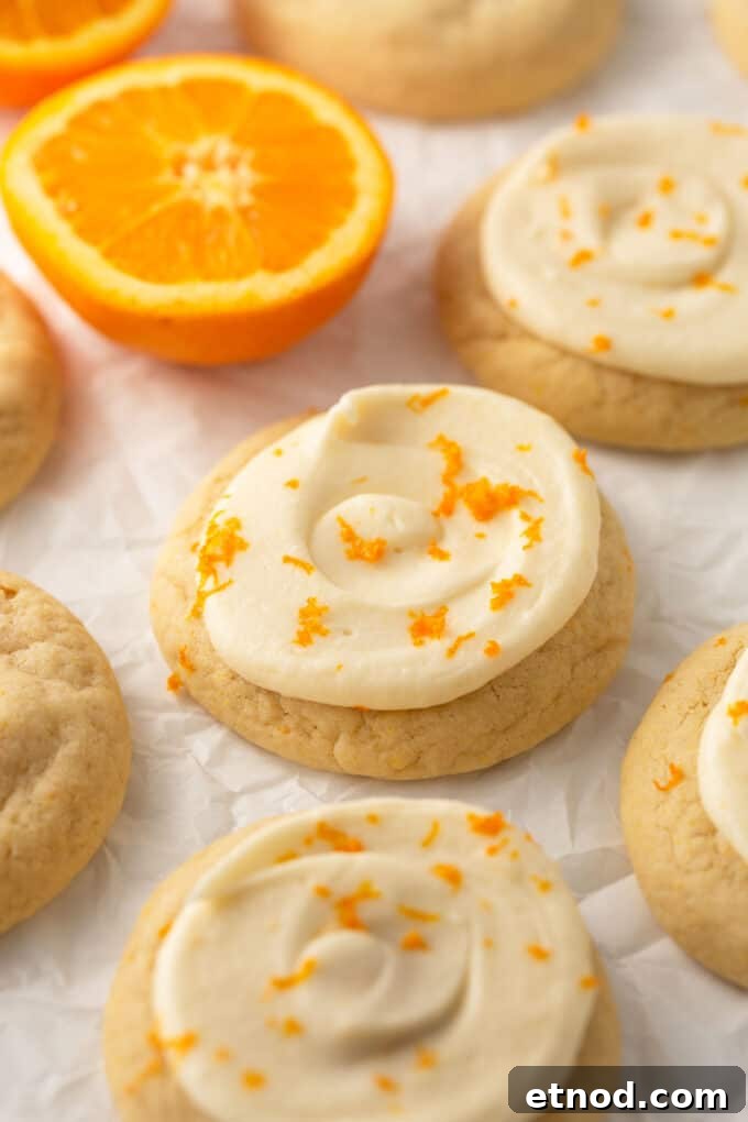 Frosted Orange Sugar Cookies Recipe with Zesty Glaze 2 orange sugar cookies with orange zest on top