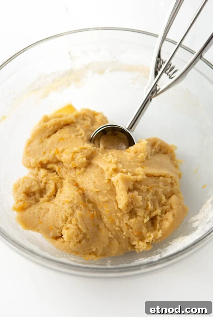 Frosted Orange Sugar Cookies Recipe with Zesty Glaze 5 bowl of raw orange sugar cookie dough with cookie scoop