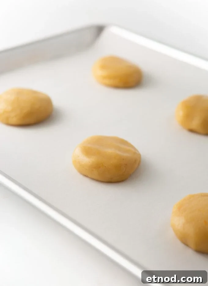 Frosted Orange Sugar Cookies Recipe with Zesty Glaze 6 orange sugar cookie dough balls slightly flattened on cookie sheet