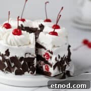 Sliced Black Forest cake on a white cake stand.