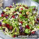 Shaved Brussels Sprouts Salad with Pomegranate and Pecans 5 shaved Brussels sprouts with pomegranate and toasted hazelnuts in bowl