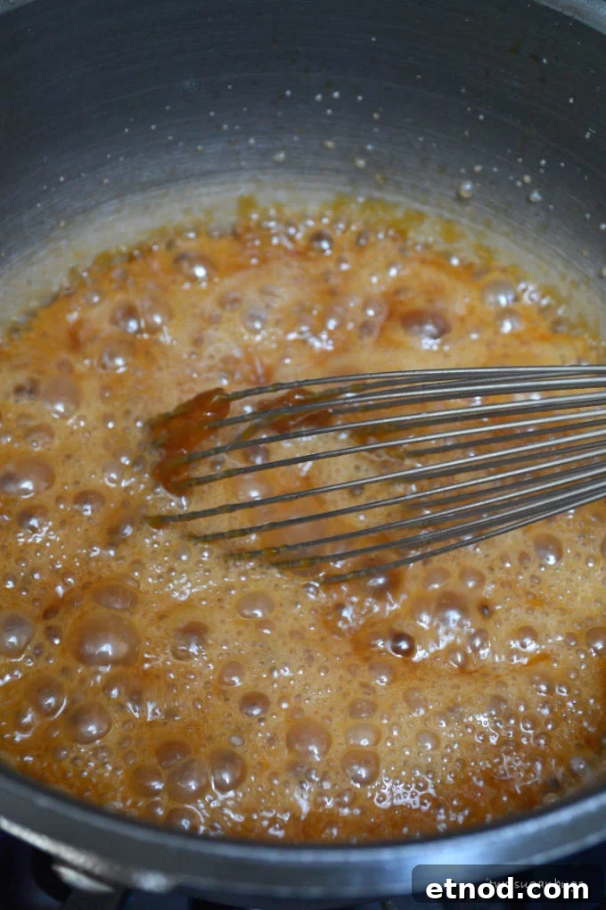 Creamy Cookie Butter Caramel Sauce Recipe 11 boiling caramel in a sauce pan with a whisk