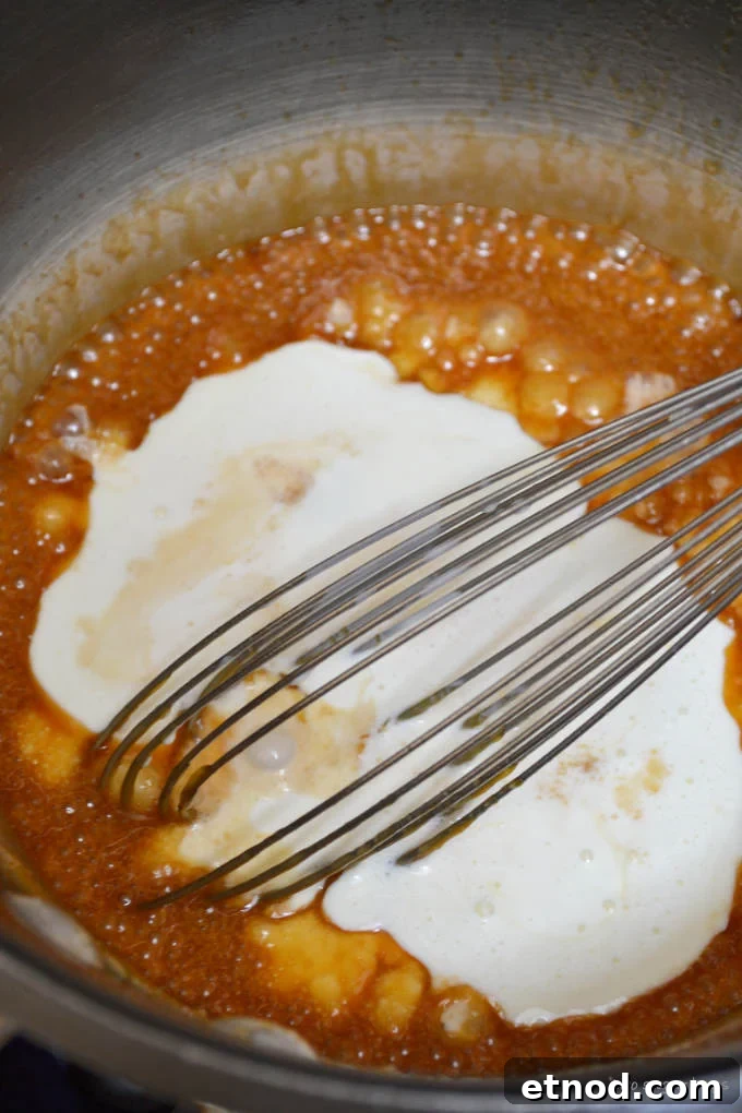 Creamy Cookie Butter Caramel Sauce Recipe 13 caramel sauce with heavy cream added in a sauce pan