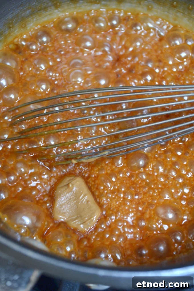 Creamy Cookie Butter Caramel Sauce Recipe 14 boiling caramel sauce with a dollop of cookie butter in the sauce pan