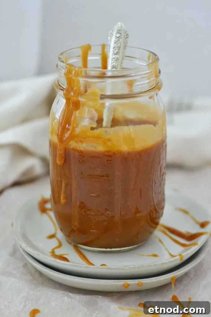 Creamy Cookie Butter Caramel Sauce Recipe 4 cookie butter caramel in a jar with a spoon