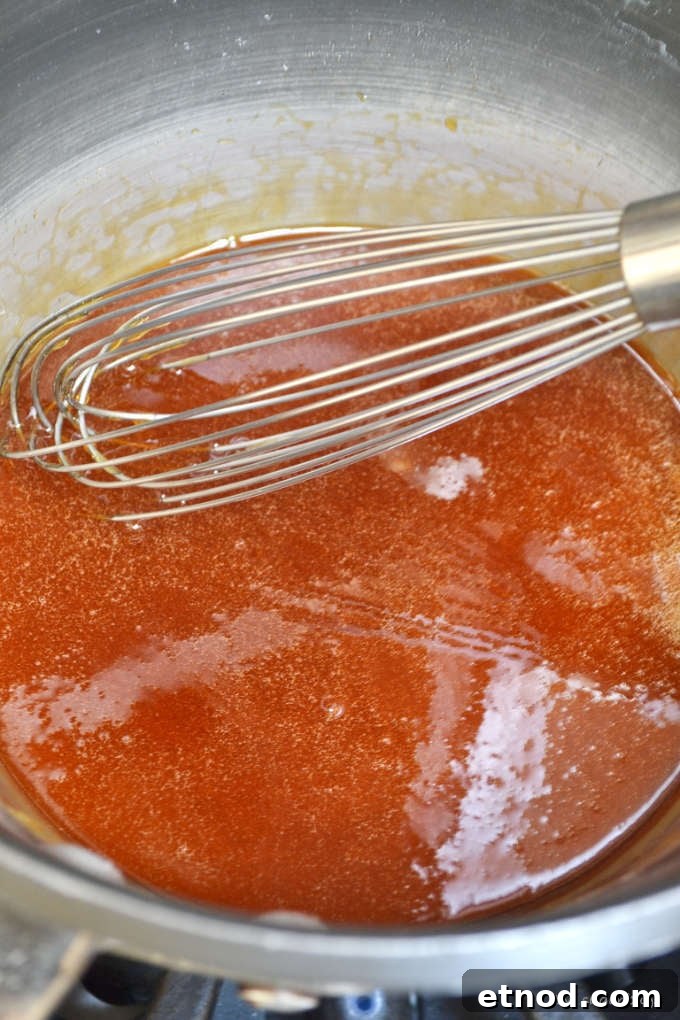 Creamy Cookie Butter Caramel Sauce Recipe 9 melted sugar in a sauce pan with a whisk