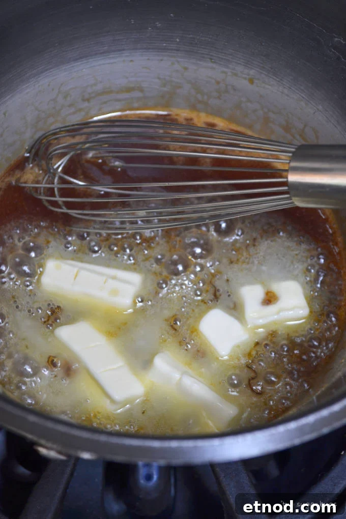 Creamy Cookie Butter Caramel Sauce Recipe 10 butter added to boiling sugar in a sauce pan